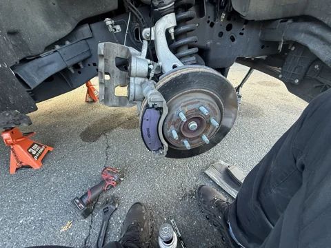 Brake pad visible beside the rotor during service.