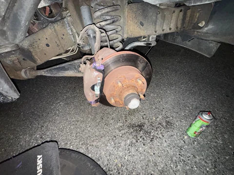 Exposed brake caliper, rotor and visible pad hardware.
