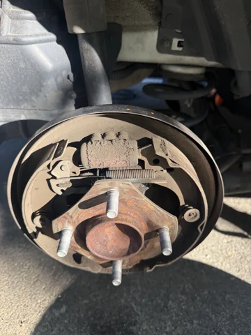 Brake shoes, return springs and wheel cylinder with the drum removed.