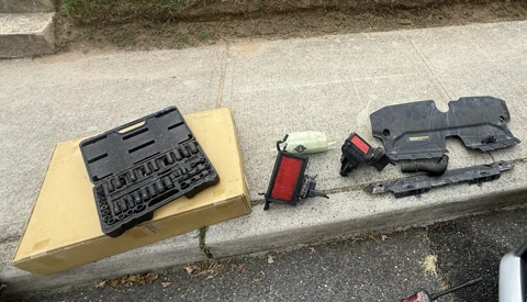 Air-filter housings and removed under-hood components laid out beside tools.
