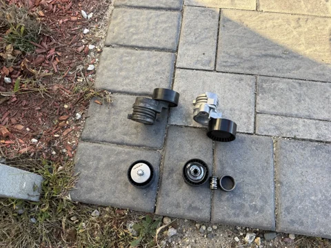 Tensioner assemblies and pulleys laid out for a closer look.